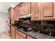 Kitchen with dark granite counters, custom cabinets, and stainless range hood at 8621 W Via Montoya Dr, Peoria, AZ 85383