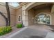 Elegant clubhouse entrance featuring an arched doorway, manicured landscaping, and decorative lighting at 9214 E Diamond Dr, Sun Lakes, AZ 85248