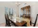 Elegant dining room with a glass-top table, classic chandelier, and a built-in china cabinet at 9214 E Diamond Dr, Sun Lakes, AZ 85248