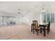 Bright dining room with large windows, neutral carpet, and a modern ceiling fan at 9214 E Diamond Dr, Sun Lakes, AZ 85248