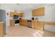 Bright kitchen with wood cabinets, a stainless steel dishwasher, and tile floor at 9214 E Diamond Dr, Sun Lakes, AZ 85248