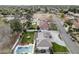 An aerial view of a home with a pool, trampoline, green grass, and a large driveway at 9505 S Kenneth Pl, Tempe, AZ 85284