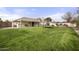 Large backyard featuring a covered patio, well-maintained lawn, trampoline, and distant view of the swimming pool at 9505 S Kenneth Pl, Tempe, AZ 85284