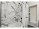 Bathroom with a tub and tiled shower featuring mosaic tile and black fixtures at 9505 S Kenneth Pl, Tempe, AZ 85284