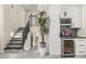 Welcoming entryway with staircase, modern iron railing, and a built-in wet bar with a wine fridge at 9505 S Kenneth Pl, Tempe, AZ 85284