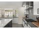 Modern kitchen design featuring a large window, white cabinets, gray countertops, and stainless steel appliances at 9505 S Kenneth Pl, Tempe, AZ 85284