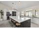 Well-lit, modern kitchen with an oversized island, barstool seating, pendant lights, and stainless appliances at 9505 S Kenneth Pl, Tempe, AZ 85284