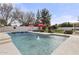 Backyard pool features a diving board, fountain, red umbrellas, and green lawn at 9505 S Kenneth Pl, Tempe, AZ 85284