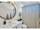 Bathroom with a circular mirror, modern sink, geometric patterned shower curtain, and blue ceiling at 9652 E Ludlow Dr, Scottsdale, AZ 85260