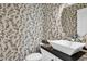 Powder room featuring a white sink, modern fixtures, a decorative mirror, and leaf-patterned wallpaper at 9652 E Ludlow Dr, Scottsdale, AZ 85260