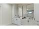 Elegant bathroom featuring dual sinks, white cabinetry, modern fixtures, and a view of the landscaped outdoors at 10242 N 58Th St, Paradise Valley, AZ 85253