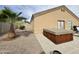 A backyard featuring a charming hot tub and complemented by desert landscaping and a palm tree at 10323 W Carousel Dr, Arizona City, AZ 85123