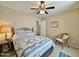 Comfortable bedroom featuring a ceiling fan, neutral walls and carpet, and a stylish accent chair at 10323 W Carousel Dr, Arizona City, AZ 85123