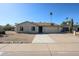 Tan single-story home featuring a two-car garage, low-maintenance desert landscaping, and a basketball hoop above the garage at 10720 E Sahuaro Dr, Scottsdale, AZ 85259