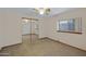 Bedroom with neutral carpet, a window with wood trim, and a closet with mirrored sliding doors at 1102 E Brown St, Phoenix, AZ 85020