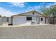 Exterior view of home, featuring a gravel yard, white siding, white trim, and white entry door at 1102 E Brown St, Phoenix, AZ 85020