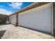 Three-car garage with white doors, gravel driveway offers ample parking and storage at 1102 E Brown St, Phoenix, AZ 85020