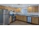 Well-lit kitchen with stainless steel appliances, granite countertops, and wooden cabinets at 1102 E Brown St, Phoenix, AZ 85020