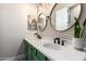 Bathroom with double sinks, wooden framed mirrors, and green cabinets providing a fresh, modern look at 11307 E Ellis St, Mesa, AZ 85207