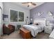 Bright bedroom with a ceiling fan, a window with shutters, a chair, a bed and a wooden chest at 11307 E Ellis St, Mesa, AZ 85207