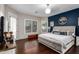 The main bedroom features a navy accent wall, dark wood floors, and a ceiling fan at 11307 E Ellis St, Mesa, AZ 85207