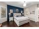 Main bedroom featuring dark wood floors, a navy accent wall, and arched doorway to bathroom at 11307 E Ellis St, Mesa, AZ 85207