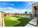 A backyard features a putting green and a pool with a safety fence at 1143 N Quinn --, Mesa, AZ 85205