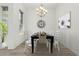 Staged dining room boasting an elegant chandelier, black dining table set for six, and a decorative wall clock at 1143 N Quinn --, Mesa, AZ 85205