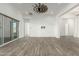 Bright, spacious living room featuring wood-look tile flooring, shiplap accent wall, and a unique windmill-style ceiling fan at 1143 N Quinn --, Mesa, AZ 85205