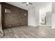 Bright living room with a brick wall, wood-style flooring, and a peek into the bathroom at 1143 N Quinn --, Mesa, AZ 85205