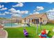 Bright backyard with a swimming pool, playset, and artificial grass for to enjoy at 11843 W Cambridge Ave, Avondale, AZ 85392