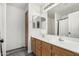 Bathroom with a double sink vanity, large mirror, and neutral finishes at 11843 W Cambridge Ave, Avondale, AZ 85392