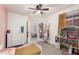 Bright bedroom with natural light, a ceiling fan, and a charming dollhouse at 11843 W Cambridge Ave, Avondale, AZ 85392