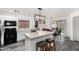 Bright kitchen features white cabinetry, a center island with seating, and an adjacent dining area at 11843 W Cambridge Ave, Avondale, AZ 85392