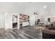 Open-concept living room featuring wood-look floors and seamless transition to kitchen with modern design elements at 11843 W Cambridge Ave, Avondale, AZ 85392