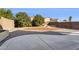 Landscaped backyard featuring a fire pit, decorative rock, mature trees, and concrete patio area at 1200 E Country Crossing Way, San Tan Valley, AZ 85143