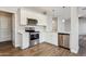 Modern kitchen featuring stainless steel appliances, white cabinets, quartz countertops, and wood-look flooring at 1200 E Country Crossing Way, San Tan Valley, AZ 85143