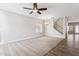 Bright living room with plush carpet, wood-look floors, a modern ceiling fan, and an elegant chandelier lighting at 1200 E Country Crossing Way, San Tan Valley, AZ 85143