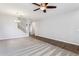 Bright living room featuring plush carpet, wood-look floors, a modern ceiling fan, and a staircase at 1200 E Country Crossing Way, San Tan Valley, AZ 85143