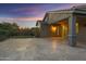 A spacious back patio with travertine flooring, outdoor lighting, and lush landscaping is perfect for entertaining at 123 W Sweet Shrub Ave, San Tan Valley, AZ 85140