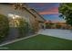 Backyard featuring artificial turf, travertine, and view of covered patio with sunset sky above at 123 W Sweet Shrub Ave, San Tan Valley, AZ 85140