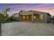 Backyard at dusk featuring a covered patio, travertine tile, exterior lighting and artificial turf at 123 W Sweet Shrub Ave, San Tan Valley, AZ 85140