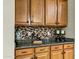 Granite countertops and a colorful backsplash add style to this kitchen's functional cabinetry at 123 W Sweet Shrub Ave, San Tan Valley, AZ 85140