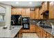 Modern kitchen featuring wooden cabinetry, granite countertops, and stainless steel appliances at 123 W Sweet Shrub Ave, San Tan Valley, AZ 85140