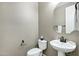 Clean powder room with a pedestal sink, toilet, mirror, and neutral wall color at 123 W Sweet Shrub Ave, San Tan Valley, AZ 85140