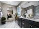 Elegant bathroom featuring a double vanity with sleek, dark cabinetry and marble-like flooring, blending style with functionality at 12551 W Parkway Ln, Avondale, AZ 85323