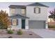 Two-story home boasts neutral stucco, blue trim, and drought-resistant landscaping, enhancing curb appeal at 12551 W Parkway Ln, Avondale, AZ 85323