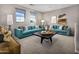 Inviting living room with two teal couches, decor, windows, and a dark wood coffee table at 12647 W Parkway Ln, Avondale, AZ 85323