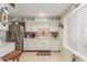 Efficient kitchen with white cabinetry, a brick backsplash, and a stainless steel refrigerator at 13019 N 98Th Ave, Sun City, AZ 85351