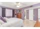 Bright main bedroom featuring hardwood floors, a ceiling fan, and easy access to the en suite bathroom at 13019 N 98Th Ave, Sun City, AZ 85351